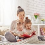 Mother reading with baby and toddler